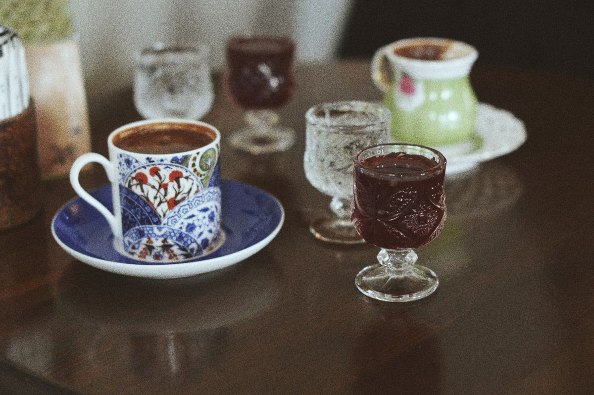 Close-up of decorative coffee cups and glassware on a wooden table, creating a warm ambiance.