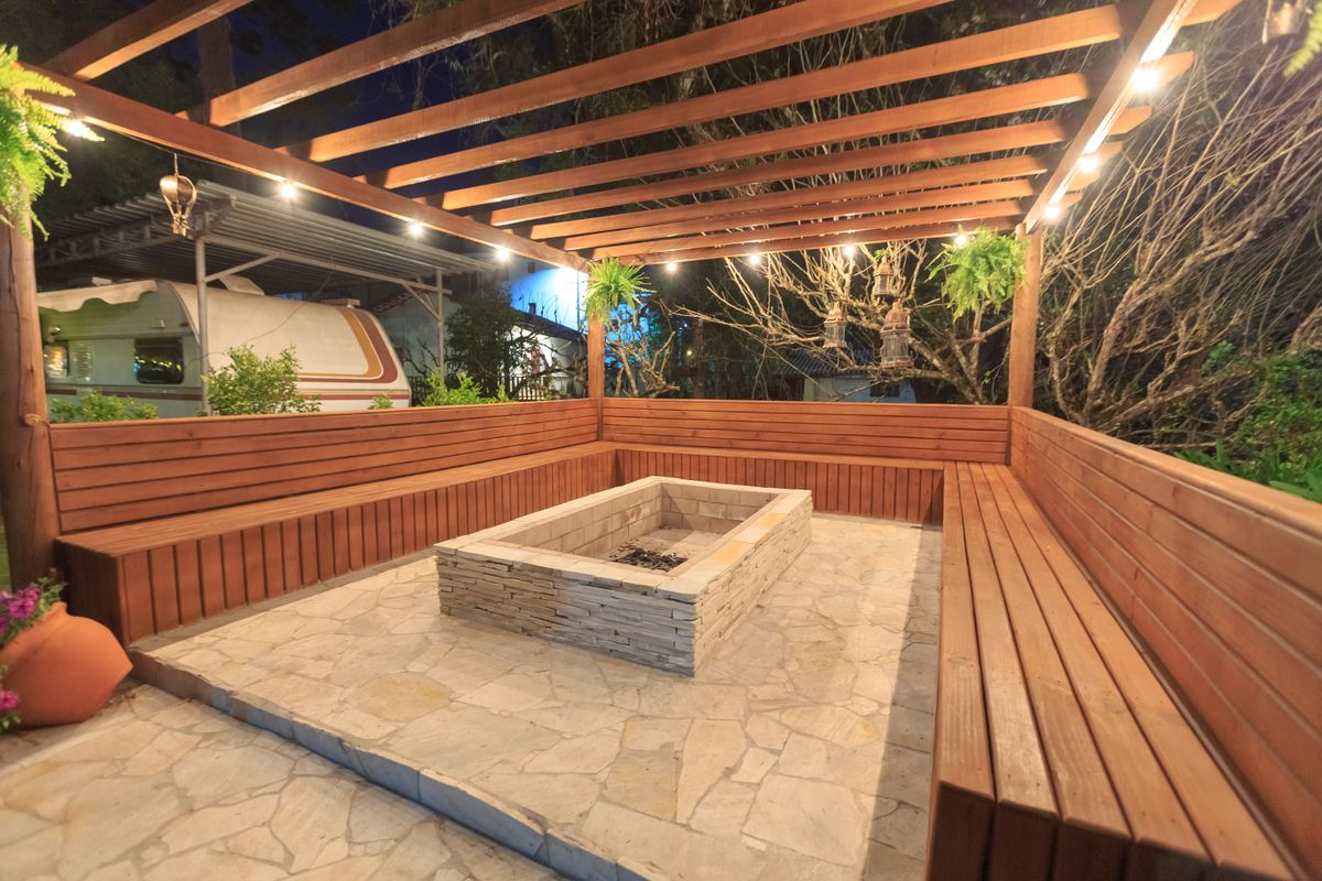 Inviting outdoor patio with wooden benches and fire pit, perfect for evening relaxation.