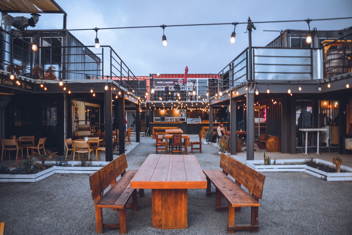 A cozy outdoor restaurant setting with string lights and wooden furniture, perfect for evening dining.