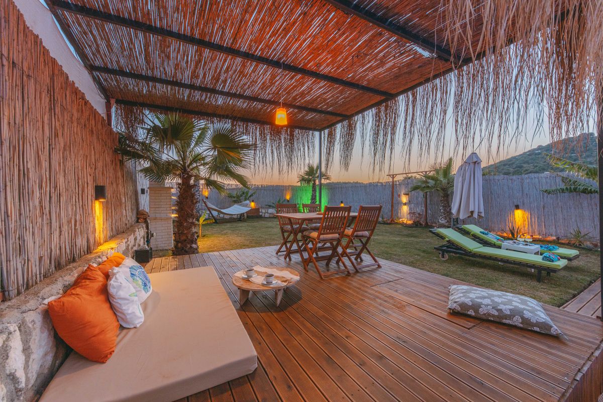 Luxurious outdoor tropical terrace with palm trees and wooden deck during a beautiful sunset. Perfect for relaxation.