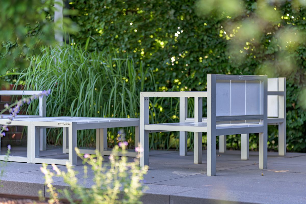 Modern outdoor furniture on a patio surrounded by lush greenery in Coesfeld.