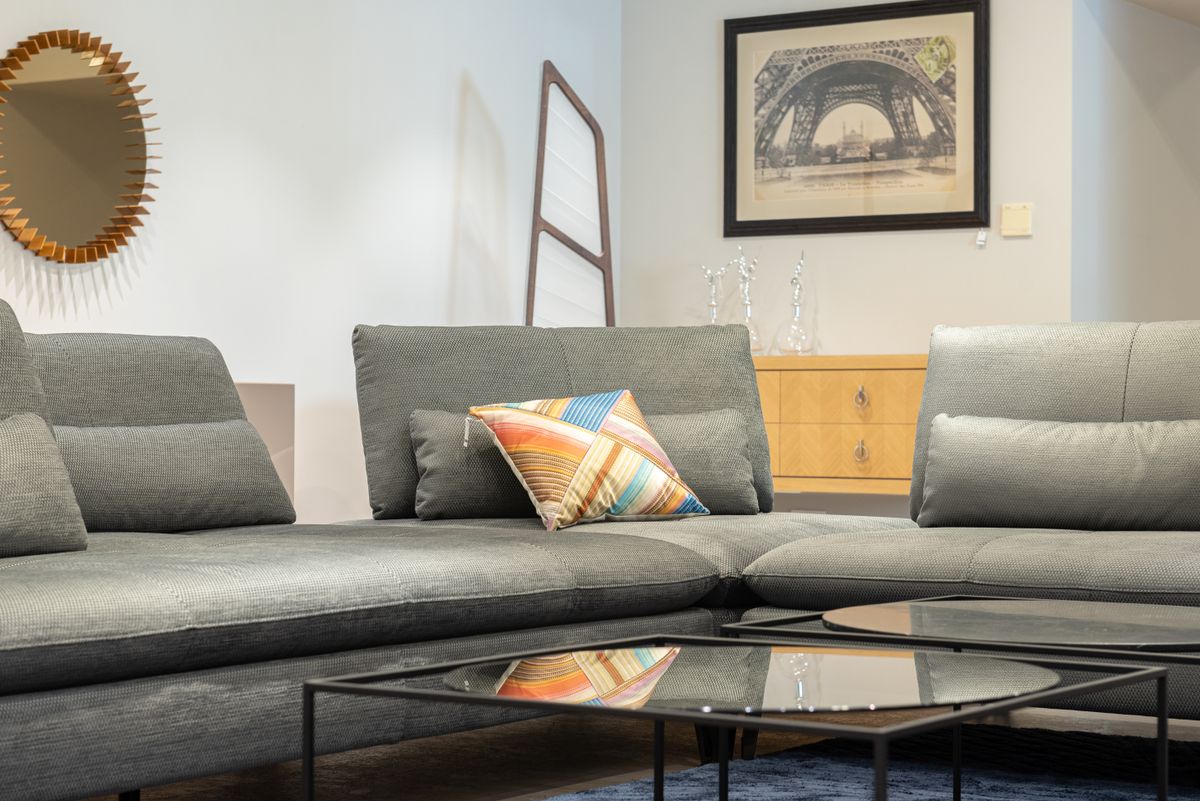Comfortable sofa with cushions placed in corner of contemporary living room near coffee table