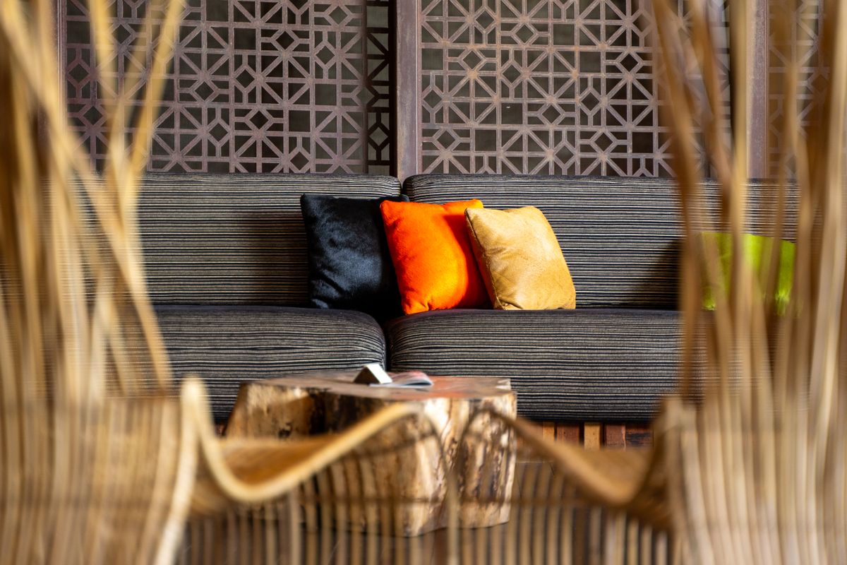 Contemporary living room featuring vibrant cushions on a striped sofa, with elegant wooden decor.