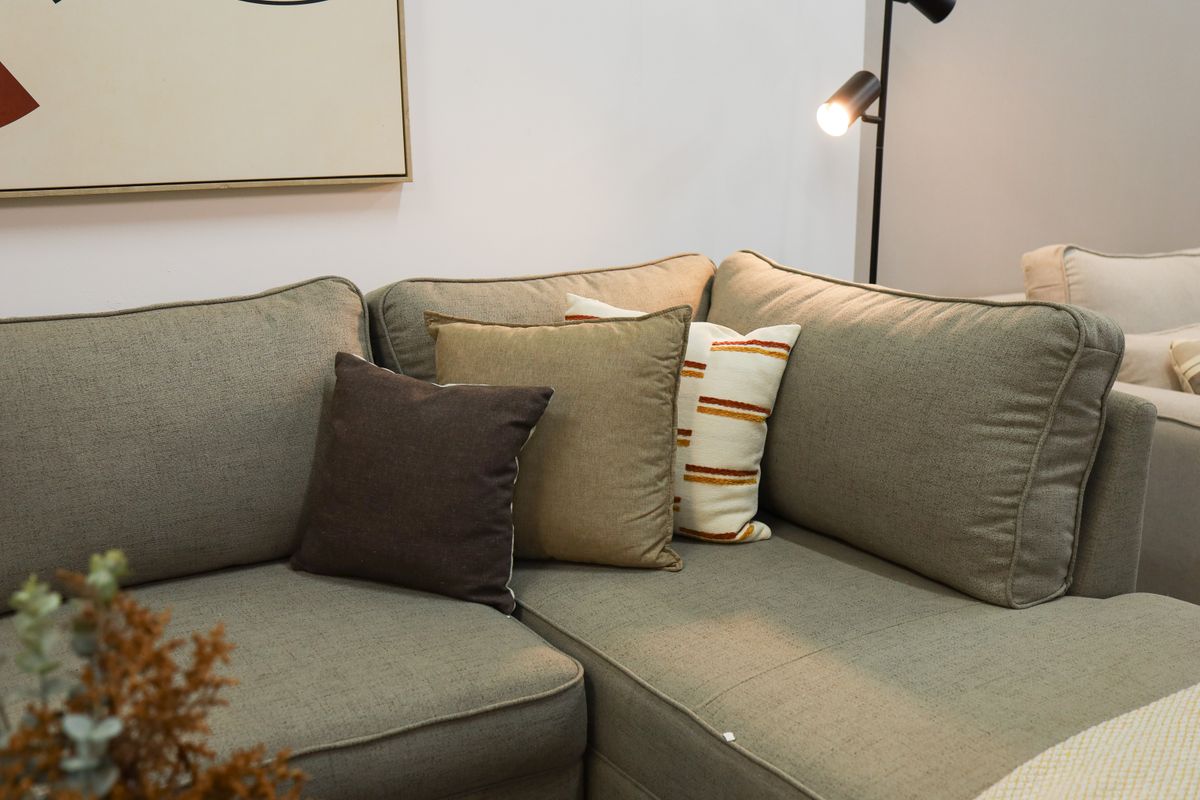 Contemporary living room featuring a modern sofa with decorative cushions and floor lamp.
