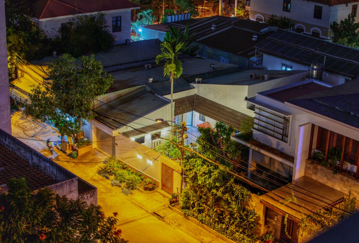 Aerial view of a well-lit residential area at night showcasing warm street lighting and palm trees.
