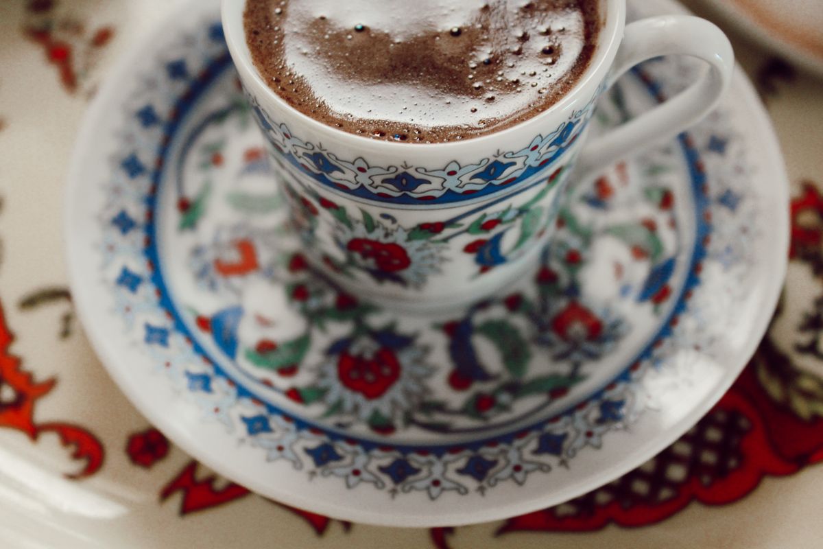Close-up of a foamy Turkish coffee in a beautifully designed porcelain cup on a saucer.