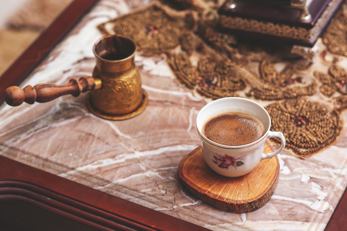 A cozy rustic setting featuring a ceramic cup of coffee on a decorative table. Perfect for lifestyle themes.