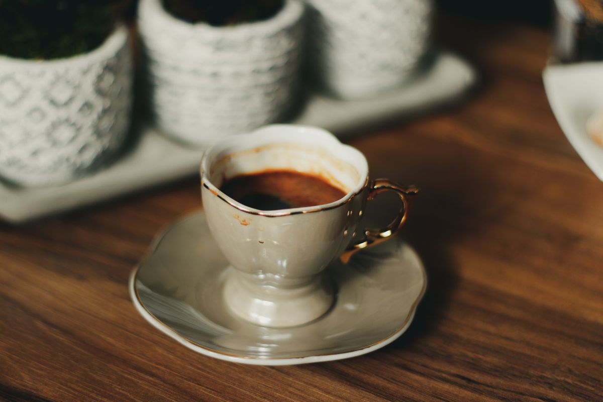 A stylish porcelain coffee cup with rich espresso on a wooden table, evoking a cozy morning.