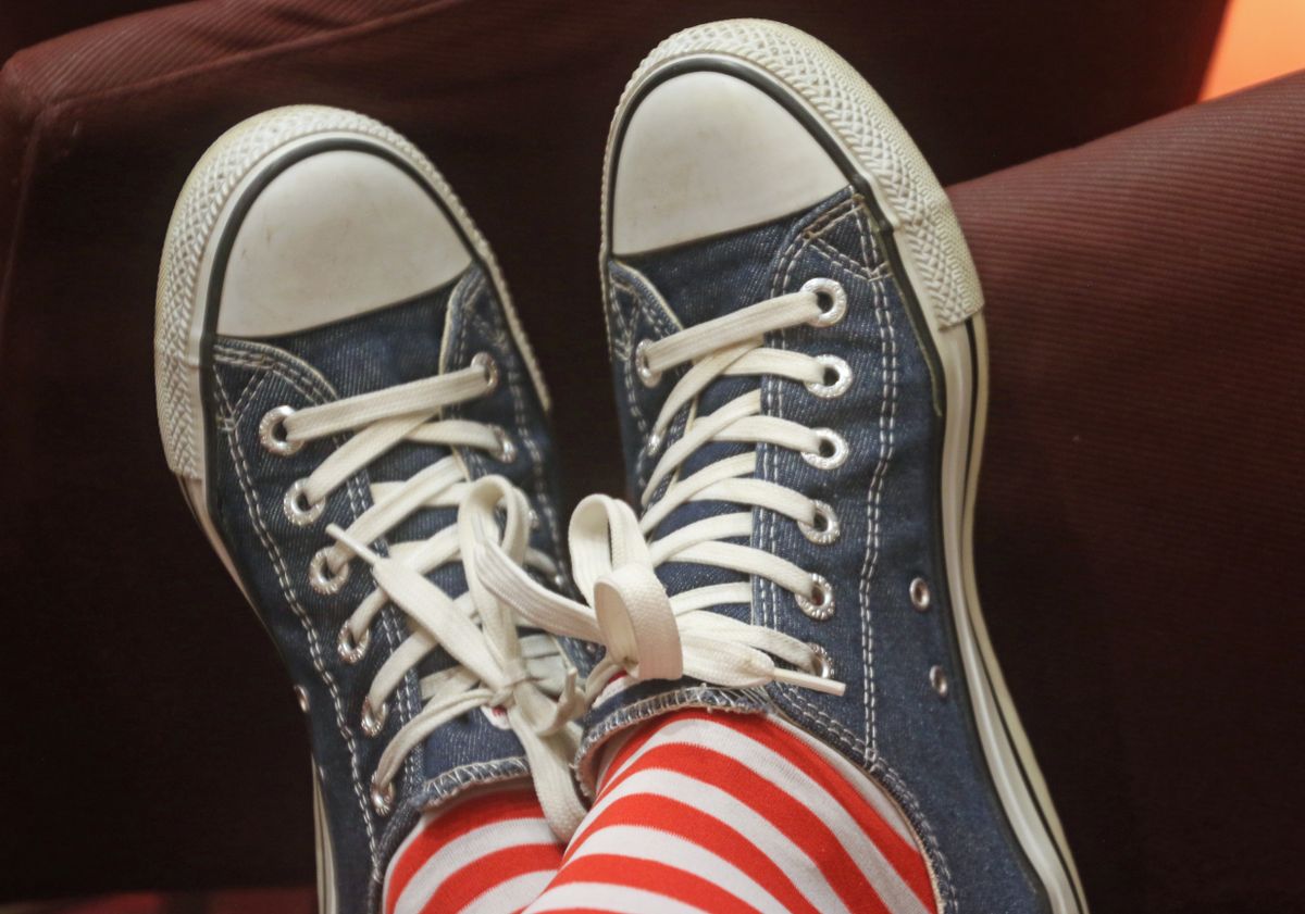 Relaxed denim sneakers paired with eye-catching red and white striped socks.