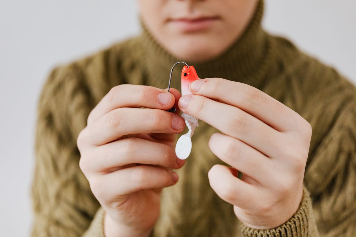 Close-up of hands setting up a fishing lure for an outdoor adventure.
