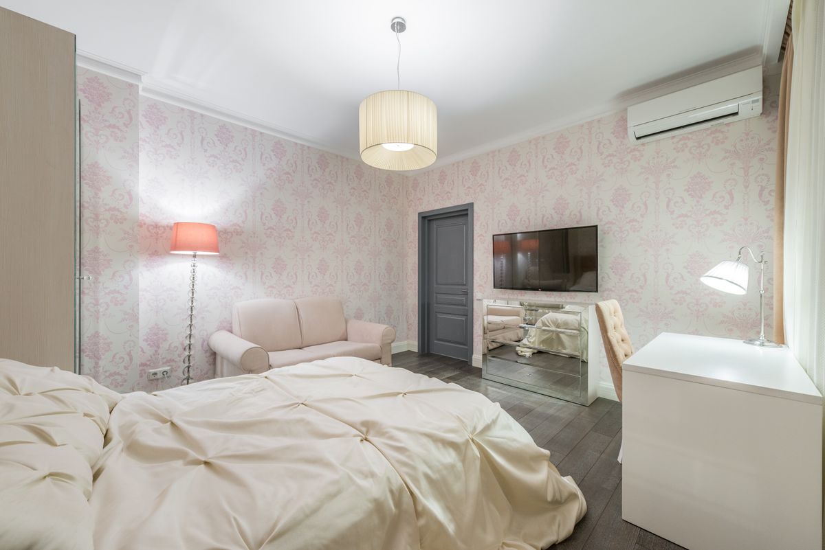 Interior of stylish bedroom with comfortable bed and light furniture in contemporary apartment