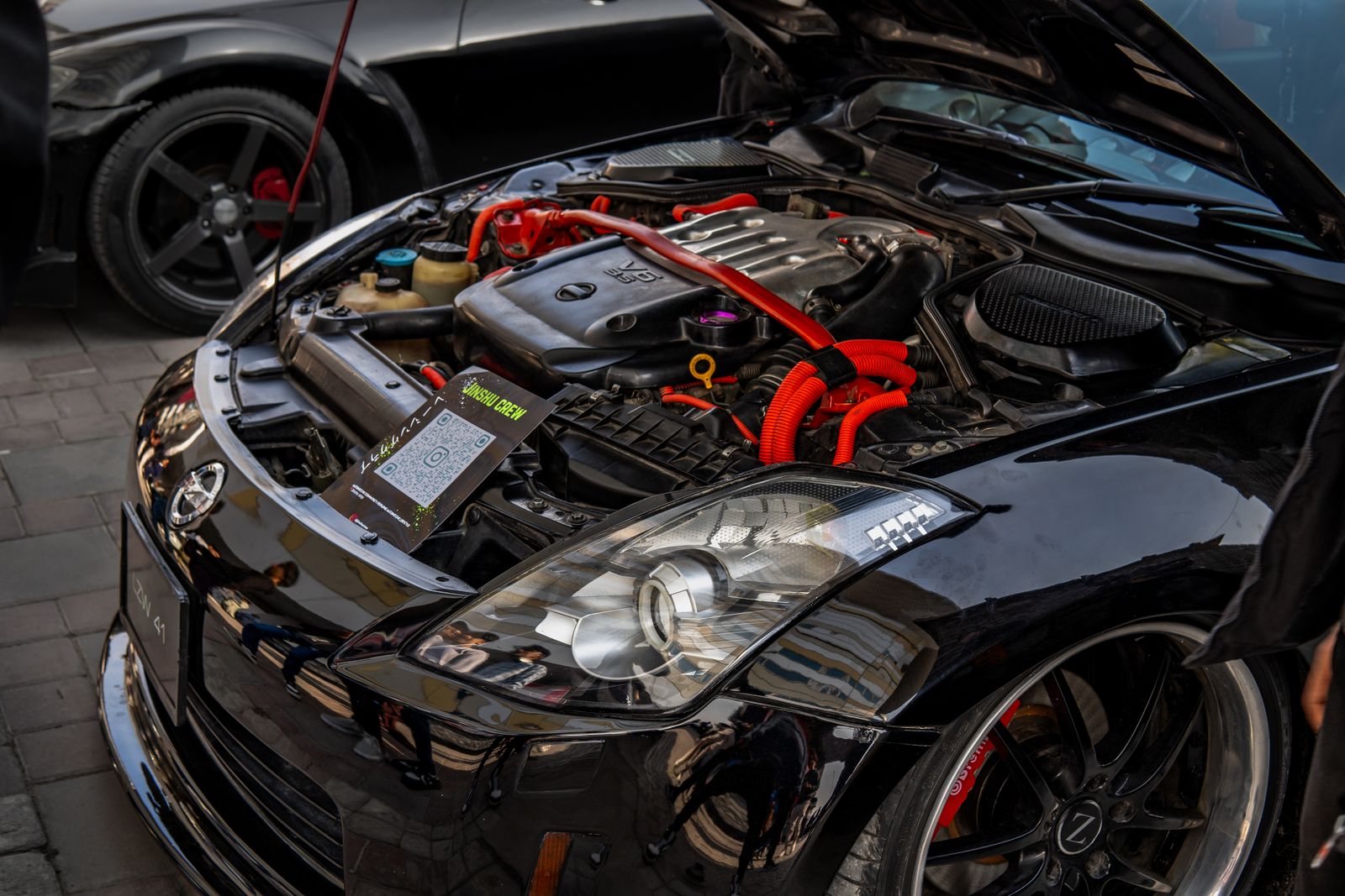 Close-up of a modified car engine with open hood in a showcase event. High-performance automotive detail.