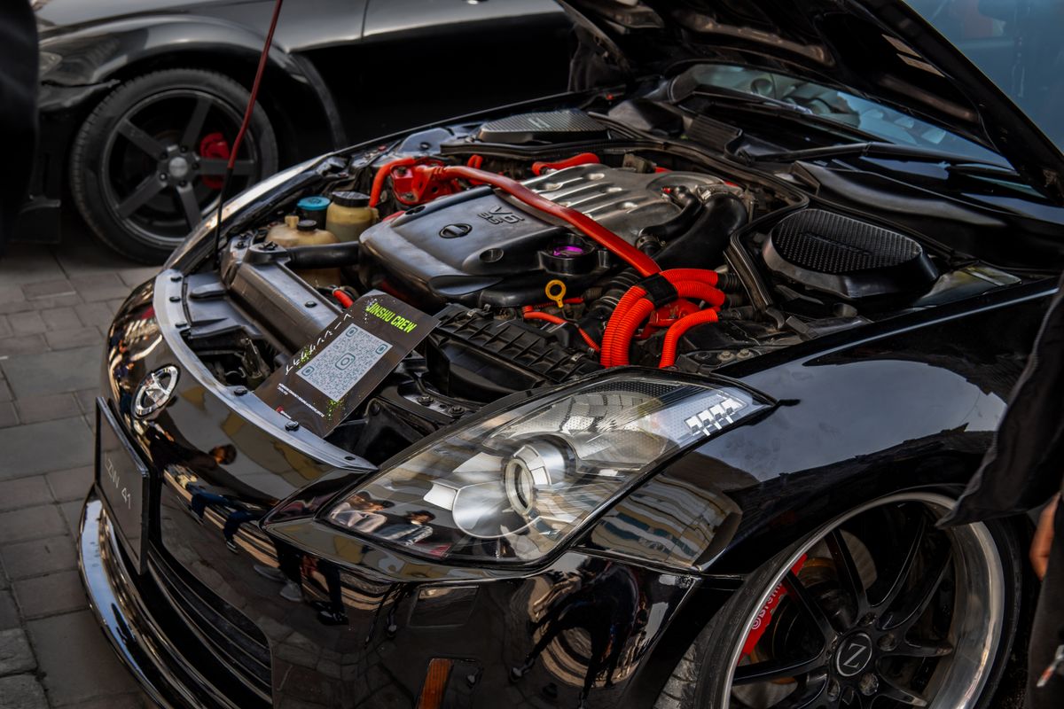 Close-up of a modified car engine with open hood in a showcase event. High-performance automotive detail.