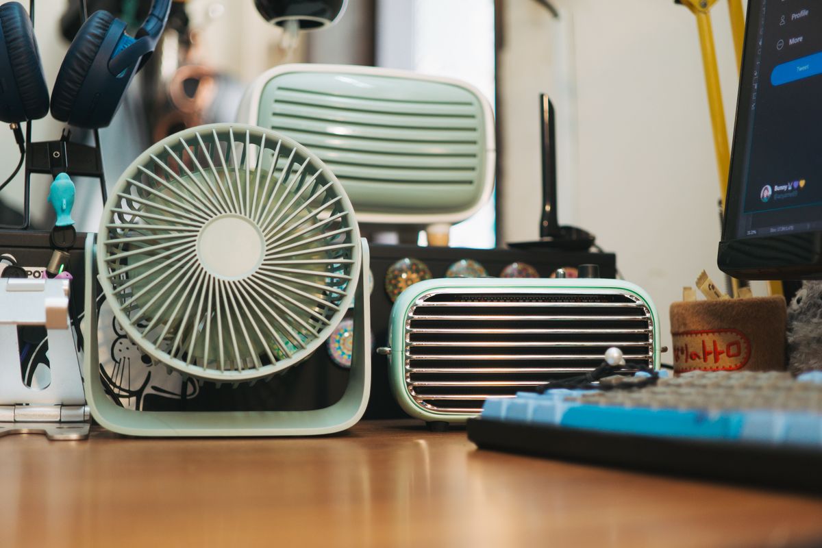 A variety of vintage electronic devices displayed on a wooden desk for a retro-themed interior.