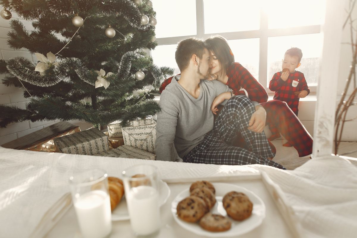A loving family enjoys a cozy Christmas morning with cookies and milk.