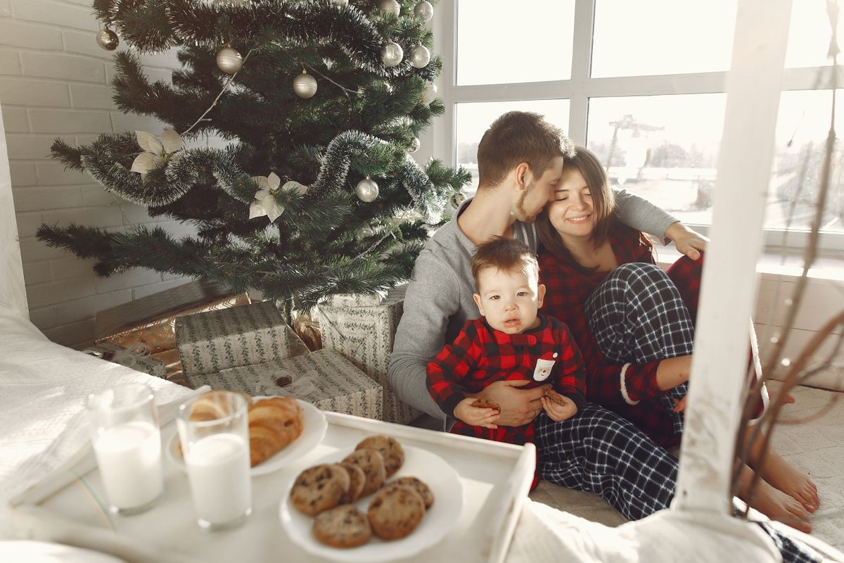 A family enjoying Christmas morning together by the tree, creating warm holiday memories.