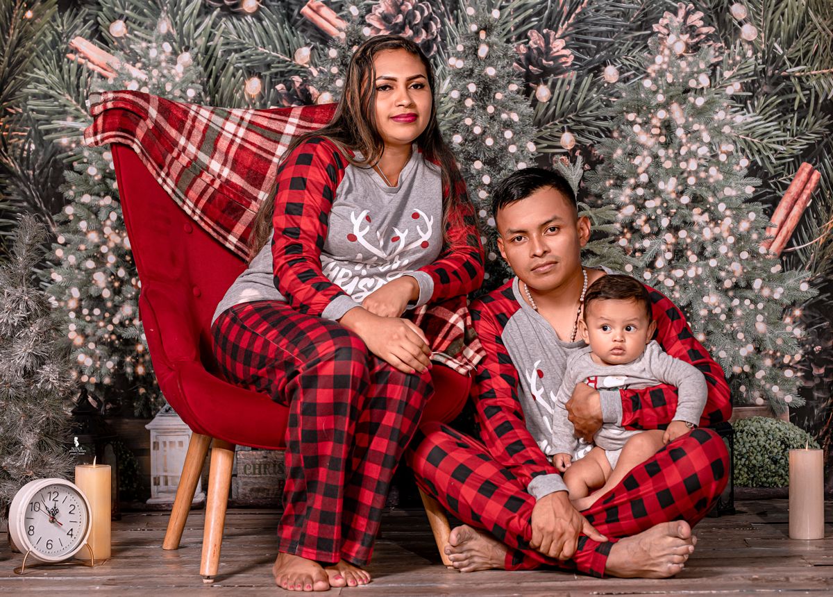 A family in matching Christmas pajamas posing warmly indoors, perfect for holiday themes.