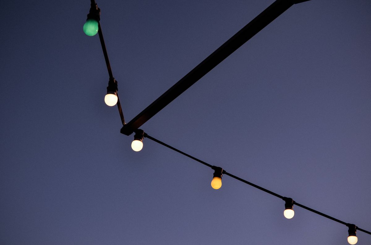 String lights hanging in a dark evening sky, creating a serene ambiance.