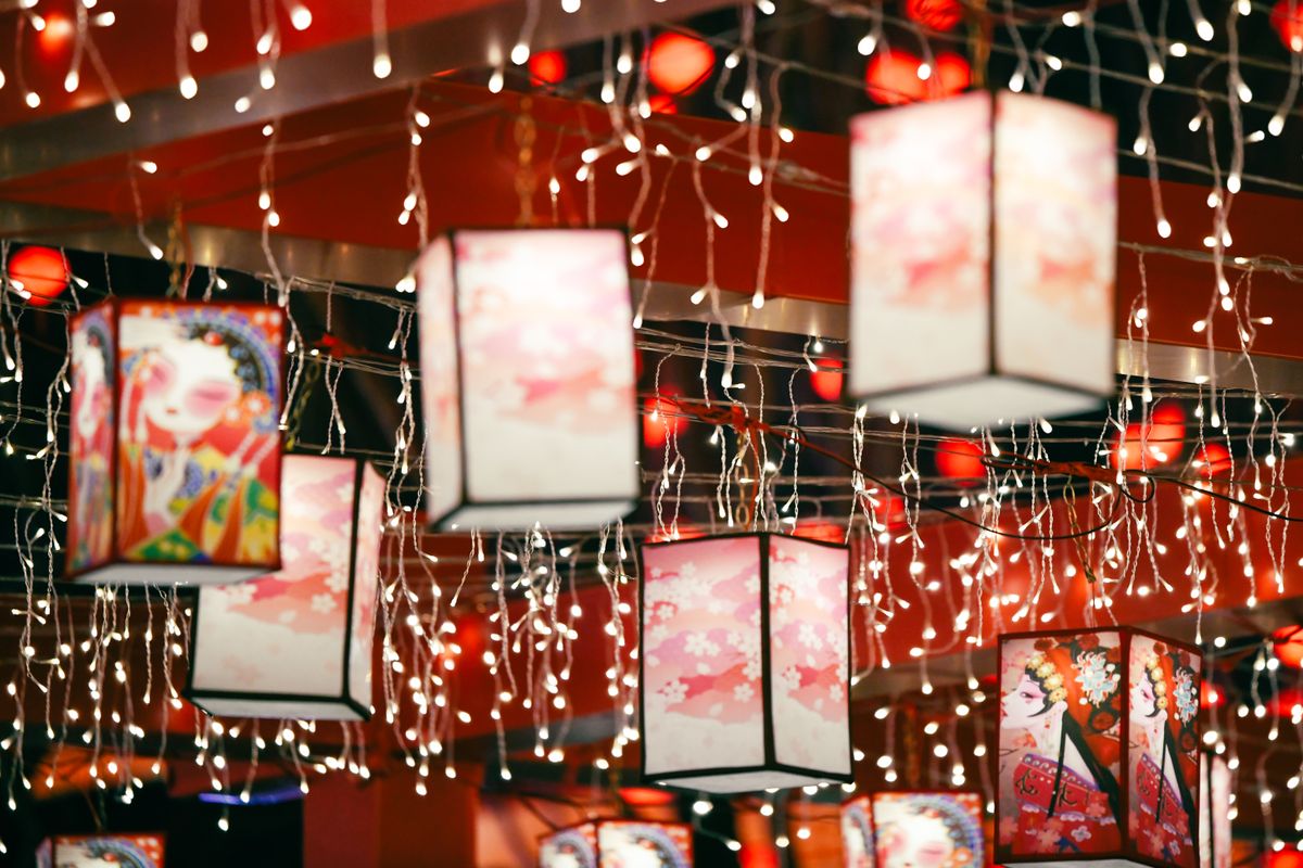 Colorful paper lanterns illuminated with decorative string lights, creating a festive ambiance.