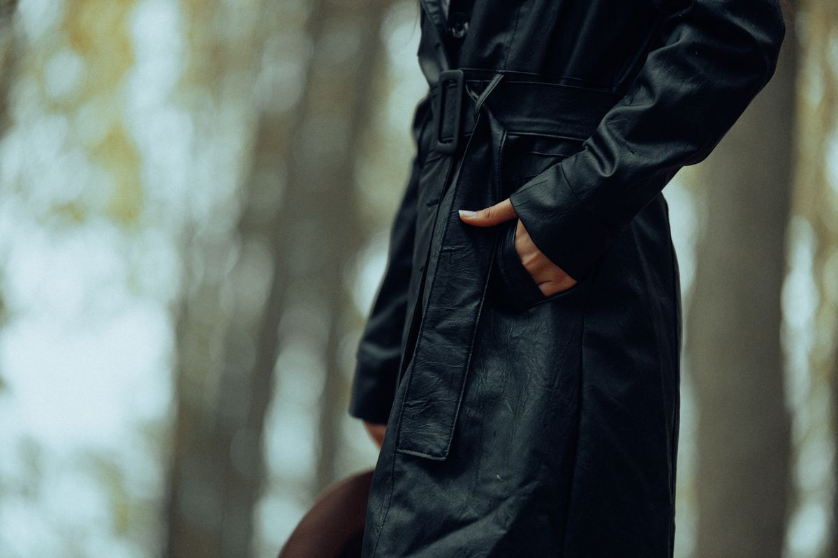 Stylish black trench coat in an autumn forest, highlighting fall fashion. Perfect for outdoor fashion shoots.