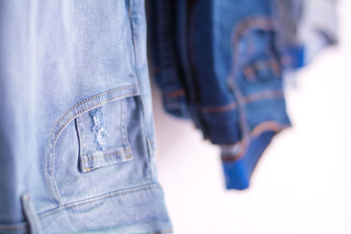 A detailed view of blue denim jeans hanging in a retail store showcasing fashion style.