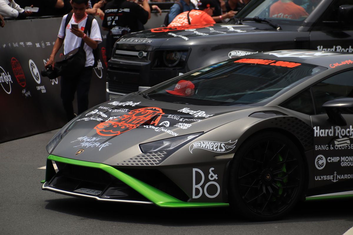 A high-performance sports car showcased in an outdoor automotive event with branding and decals.