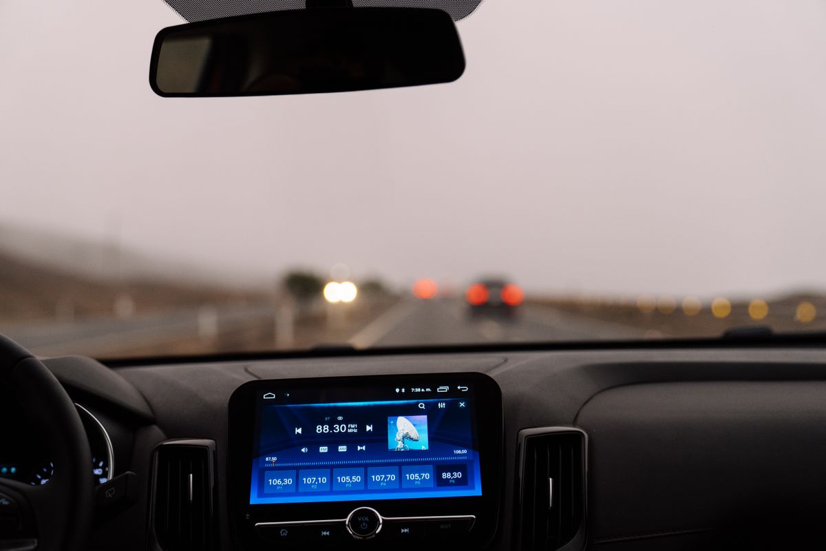 Interior view of a car dashboard on an open road during the day. Perfect for travel-themed projects.