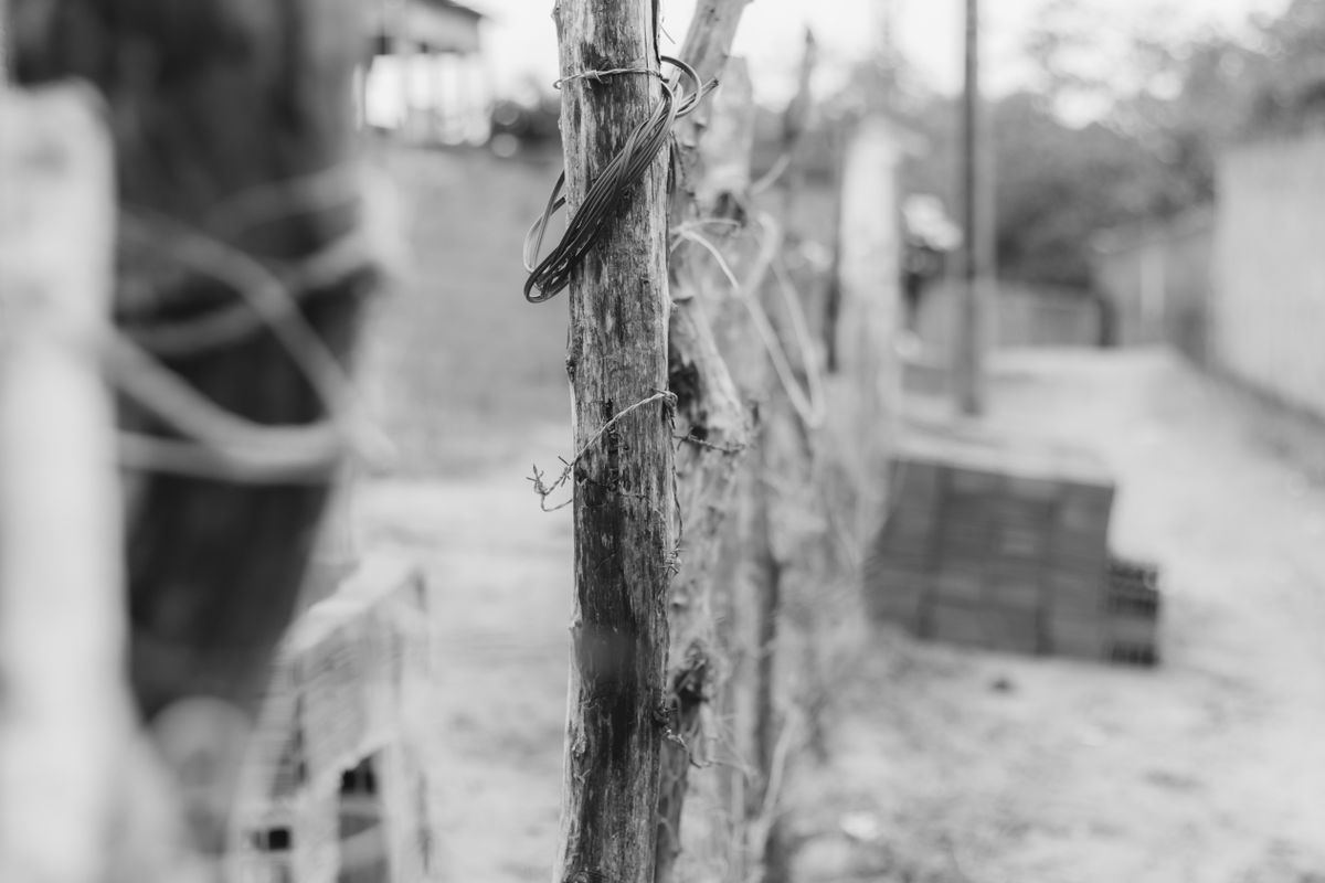 Black and white image of a rustic wooden fence with barbed wire in Aracati, Brazil.