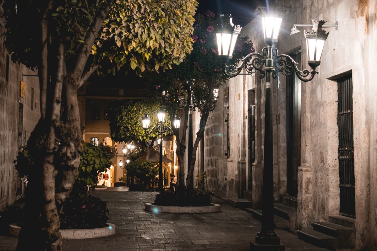 Elegant night street in Arequipa, Peru, with illuminated lanterns and historic architecture.