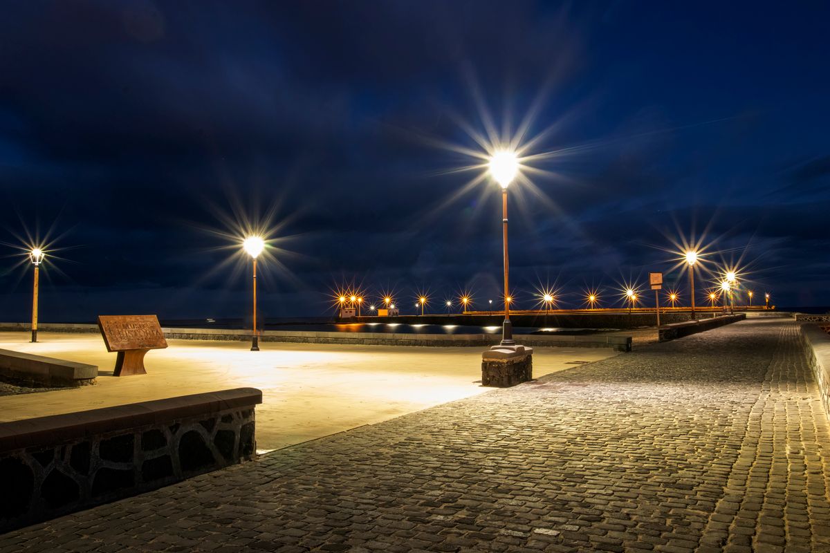 Charming cobblestone street in Lanzarote illuminated by streetlights at night.