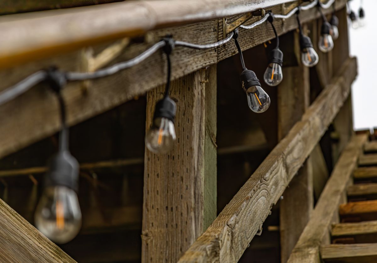 Close-up of rustic wooden structure with string lights, creating a warm ambiance.
