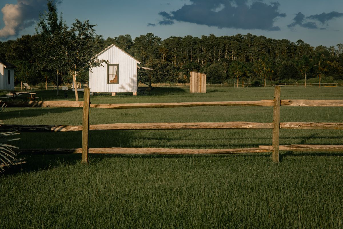 Charming rural landscape in Kissimmee, FL featuring a wooden fence and white house.