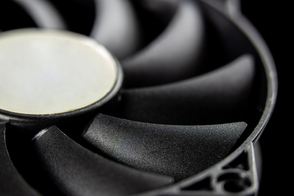 Macro close-up of a modern computer cooling fan blade, showcasing intricate details.