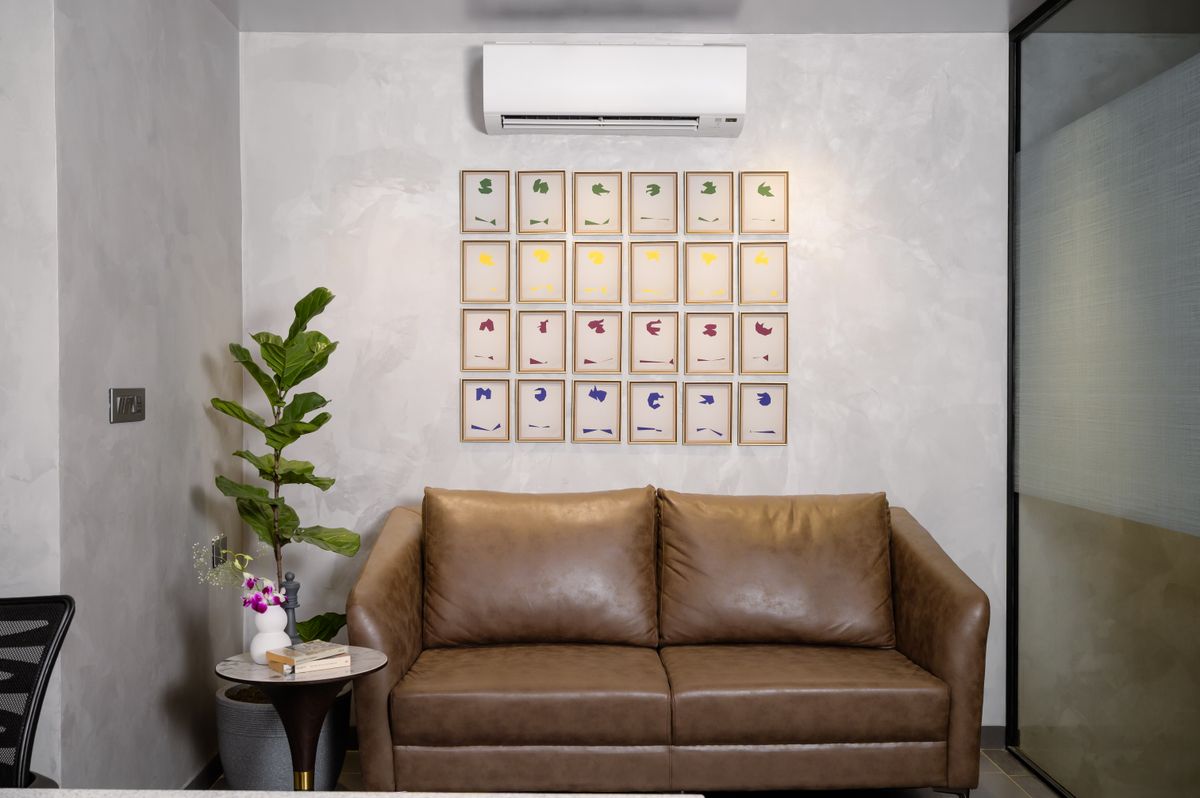 Stylish living room interior with brown sofa, wall art, and potted plant.