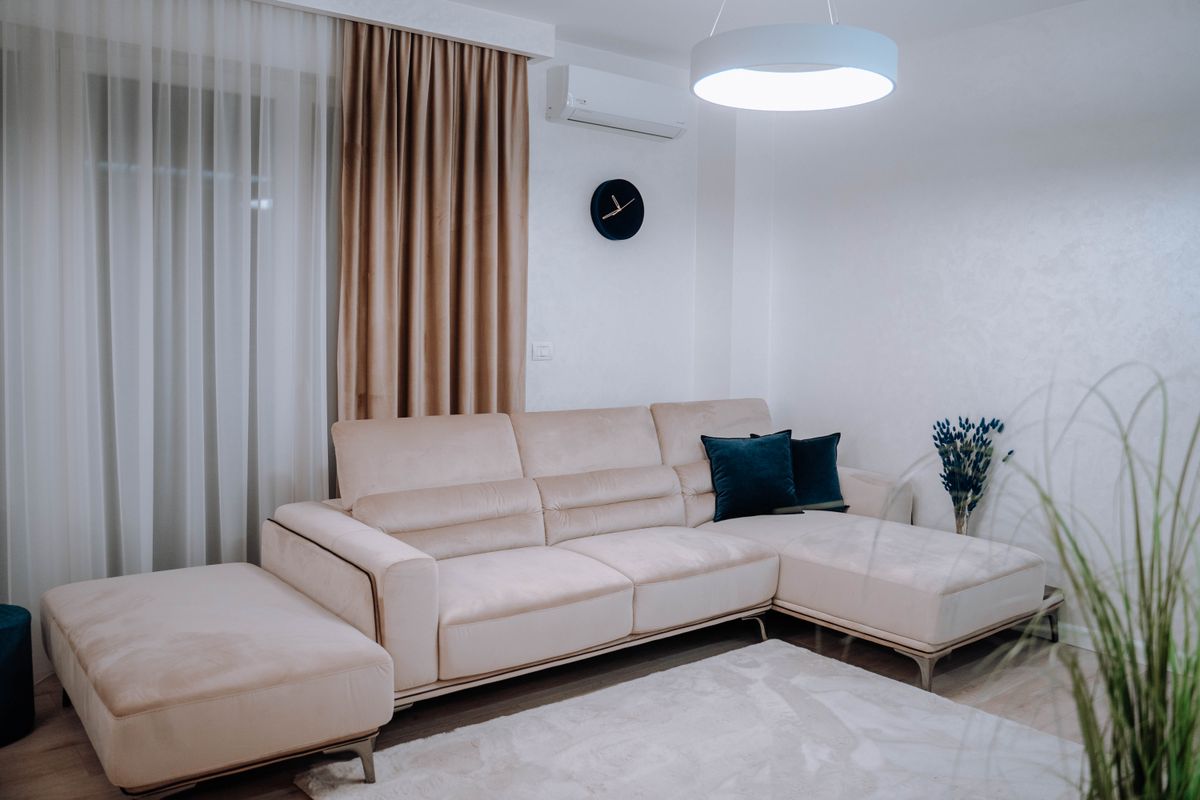 A contemporary living room featuring a beige sectional sofa and elegant decor in a bright setting.