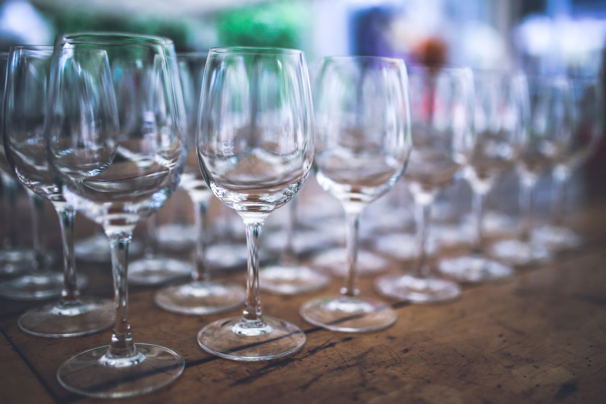 Elegant arrangement of empty wine glasses on a rustic wooden table.