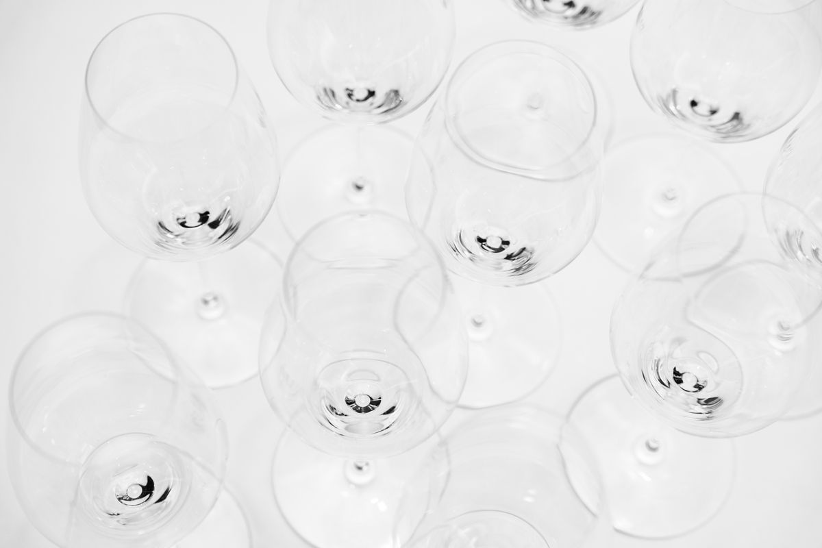An artistic overhead shot showcasing a modern display of empty wine glasses on a white background.