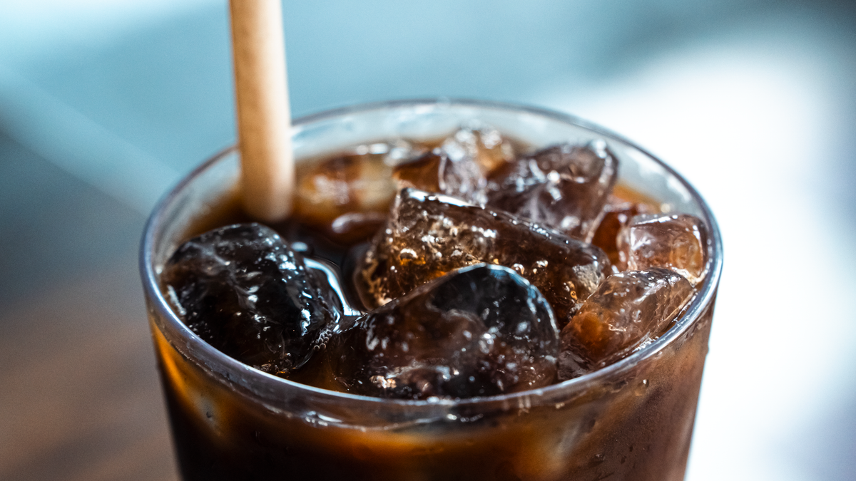 Close-up of a glass of iced coffee with ice cubes and a straw, refreshing drink.
