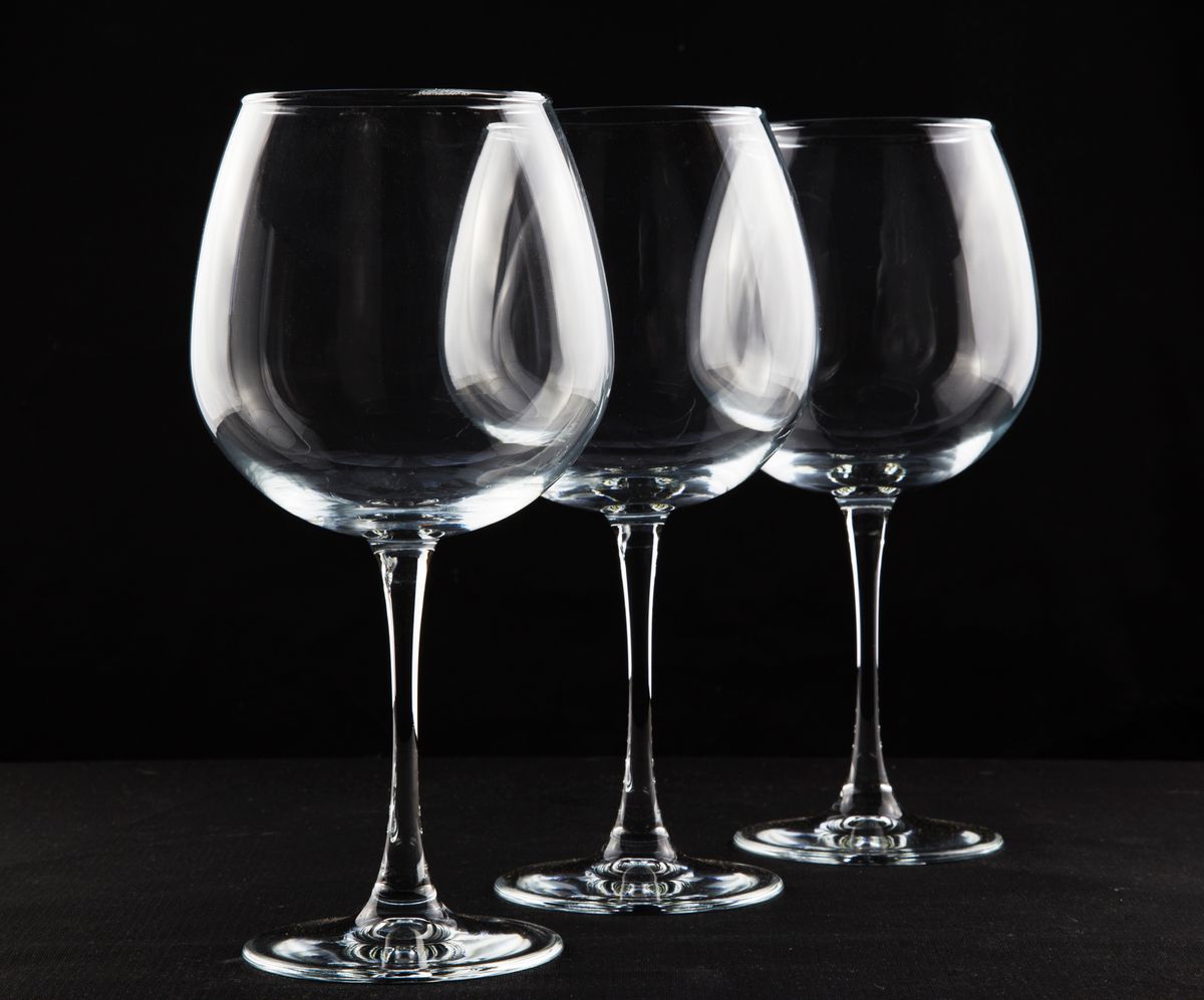 Three crystal wine glasses elegantly arranged against a black backdrop, perfect for dining and lifestyle themes.