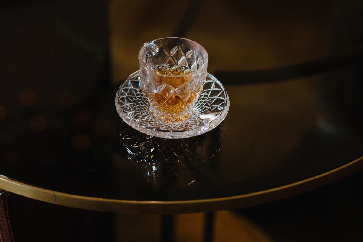 Beautifully crafted crystal glass on a reflective table surface, showcasing a modern minimalist setting.