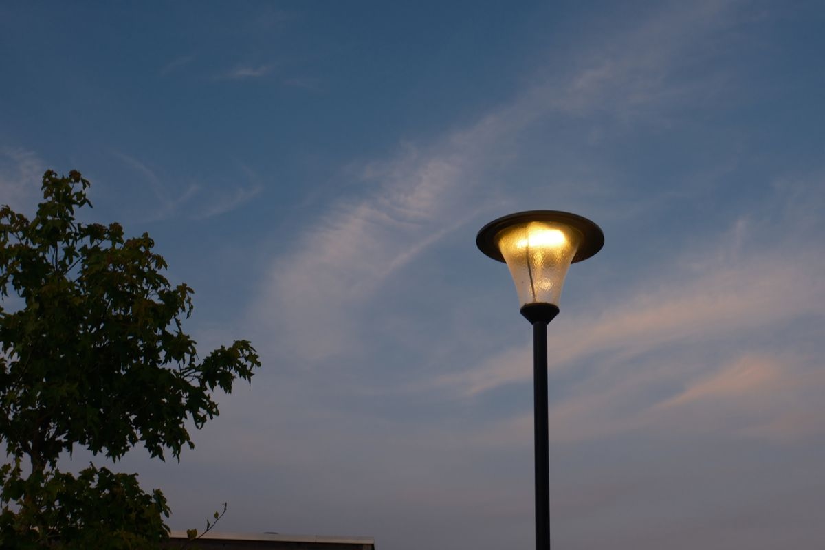 A street lamp glows warmly against a backdrop of a serene evening sky.