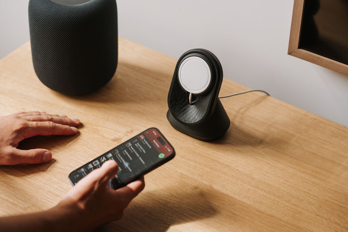 A modern desk setup featuring tech gadgets with a smartphone and smart speaker.