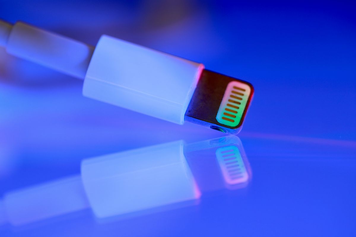 A close-up of a USB cable with colorful reflections on a shiny surface, emphasizing technology and connectivity.