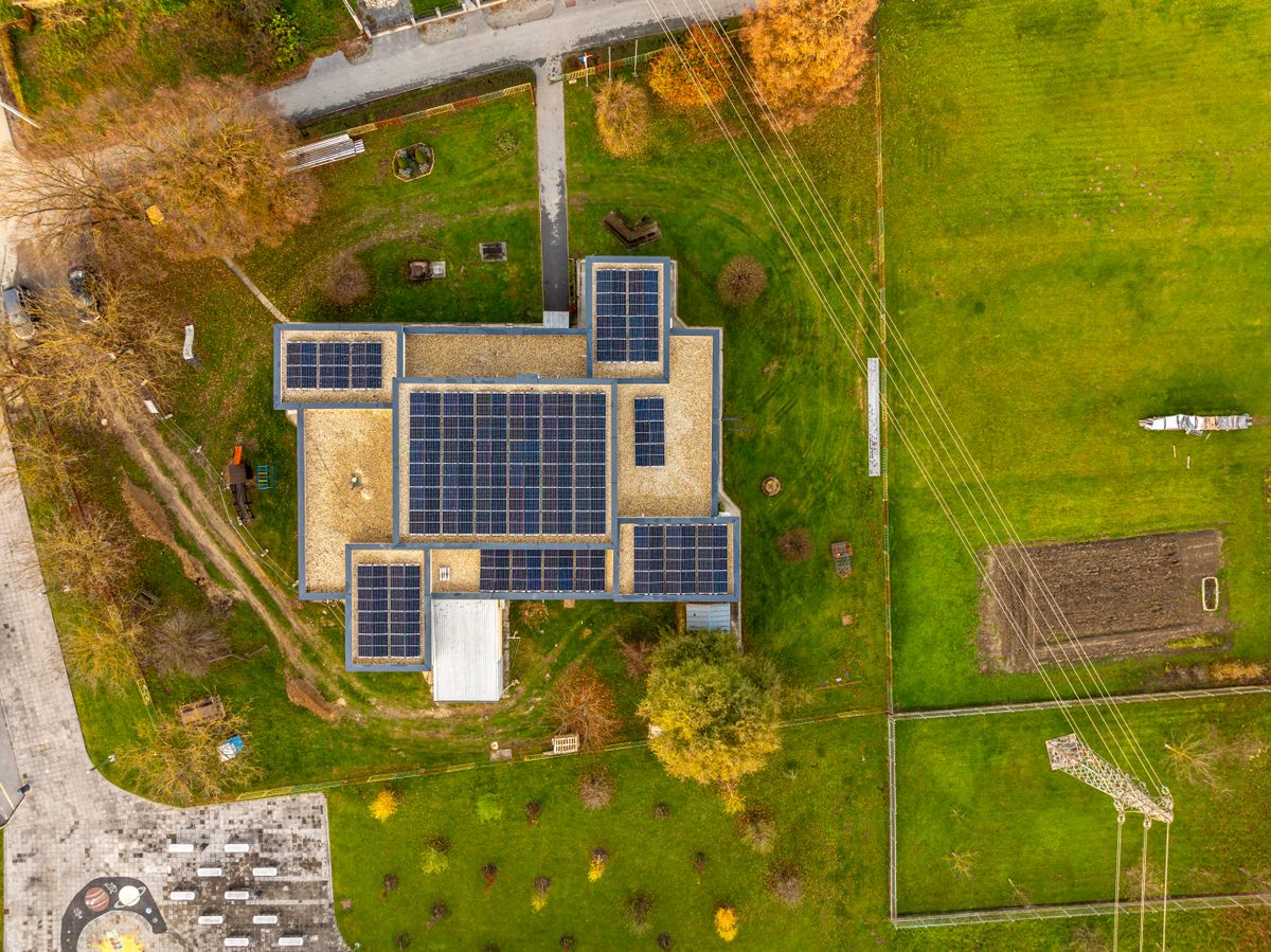 Aerial shot of a building with solar panels in a green landscape in Garešnica, Croatia.