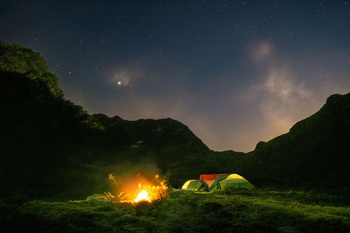 Enjoy a peaceful night camping under a starry sky with a warm bonfire.
