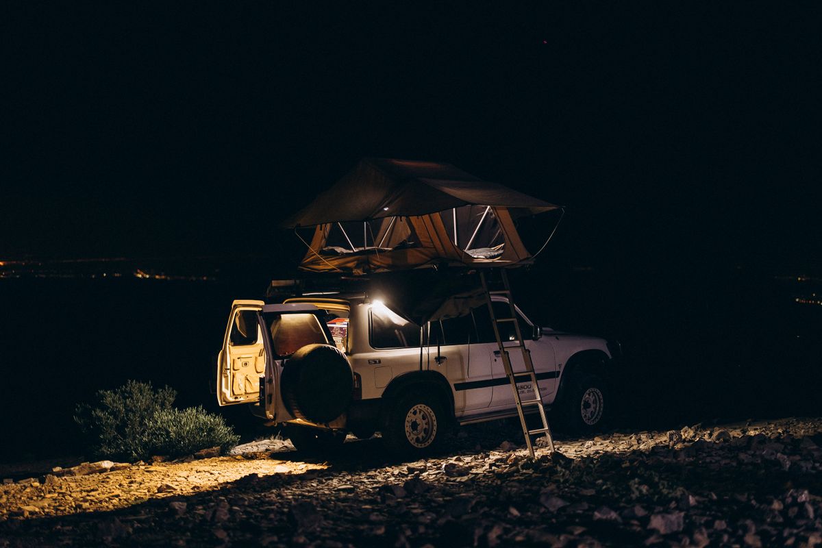 Explore 4x4 off-road camping under a vibrant starry night sky in the scenic landscapes of Oman.