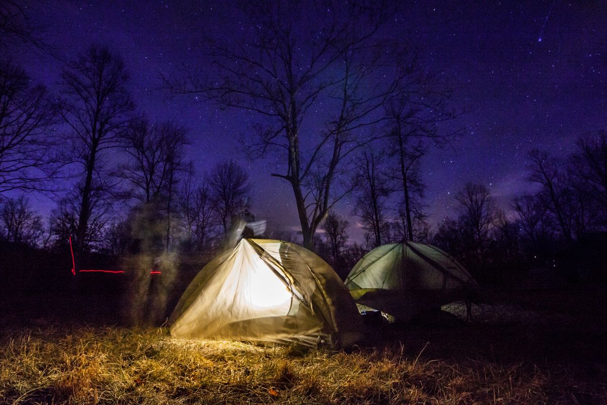 Tents illuminated beneath a starry night sky, capturing the essence of outdoor adventure.