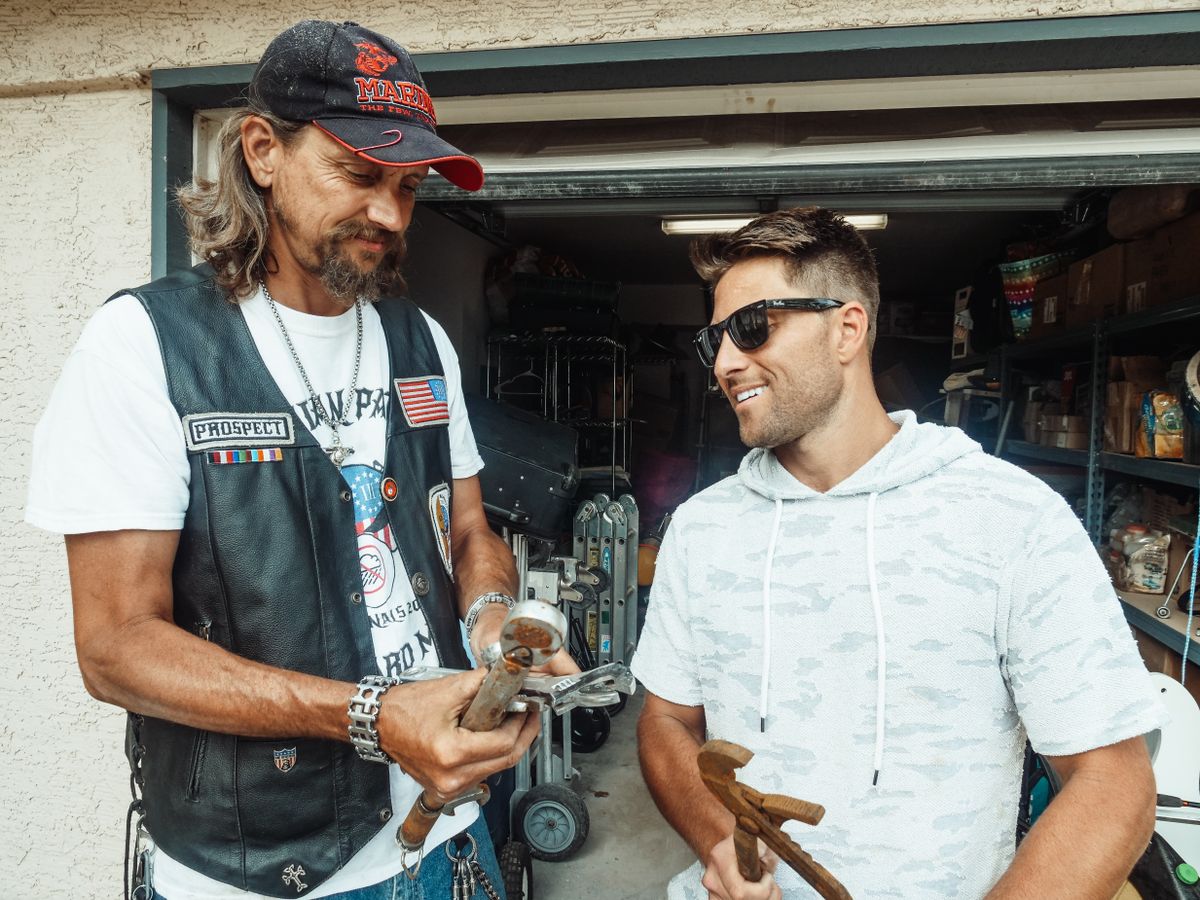 Father and son enjoying quality time in a garage, sharing smiles and tools.