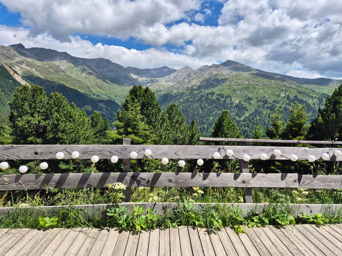 Captivating mountain landscape and wooden deck with string lights in summer.