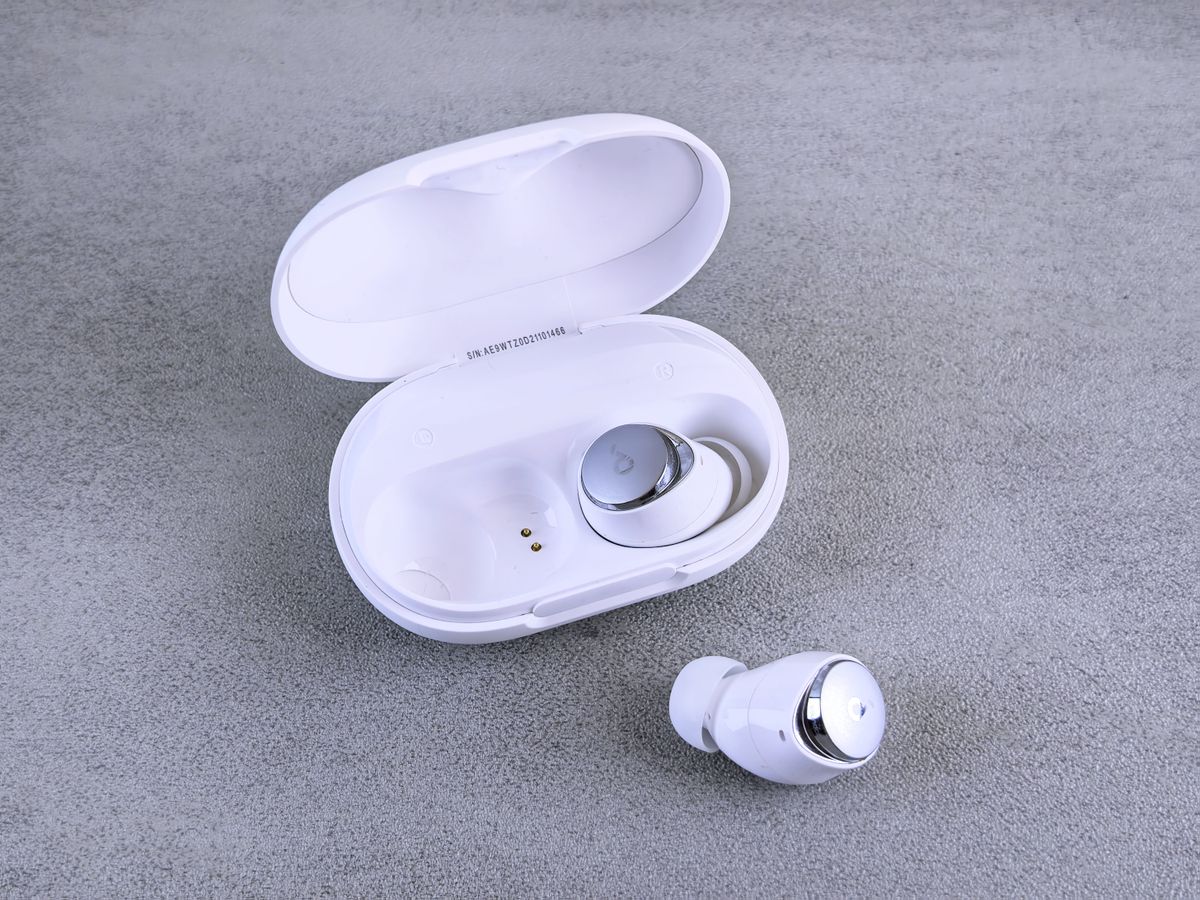 High-quality image of white wireless earbuds and charging case on a textured surface.